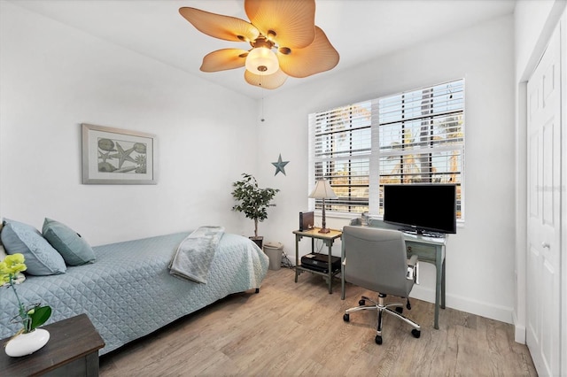 bedroom with ceiling fan, light hardwood / wood-style floors, and a closet