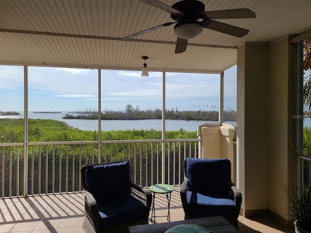 sunroom / solarium featuring a water view, ceiling fan, and a healthy amount of sunlight