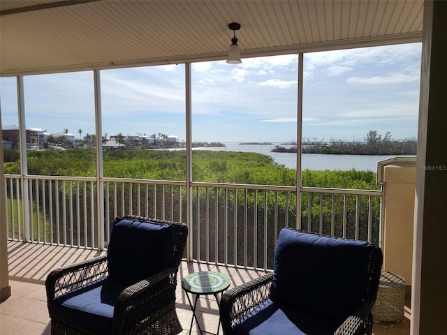 sunroom featuring a water view