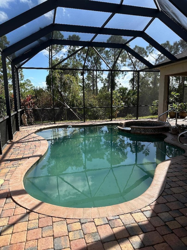 view of swimming pool with a patio, a lanai, and an in ground hot tub