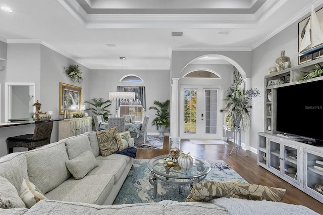 living room featuring dark wood-type flooring, crown molding, and a tray ceiling