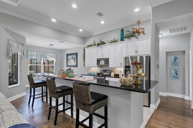 kitchen with a large island, appliances with stainless steel finishes, light hardwood / wood-style flooring, and white cabinetry