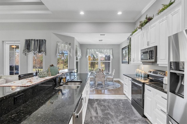 kitchen featuring light hardwood / wood-style flooring, dark stone counters, sink, white cabinets, and appliances with stainless steel finishes