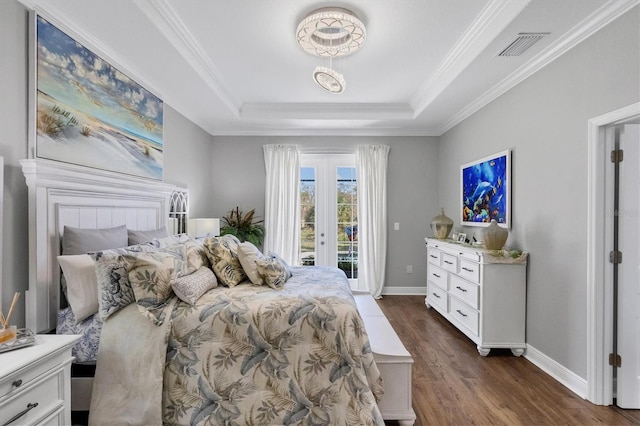 bedroom featuring ornamental molding, dark hardwood / wood-style floors, access to exterior, and a tray ceiling