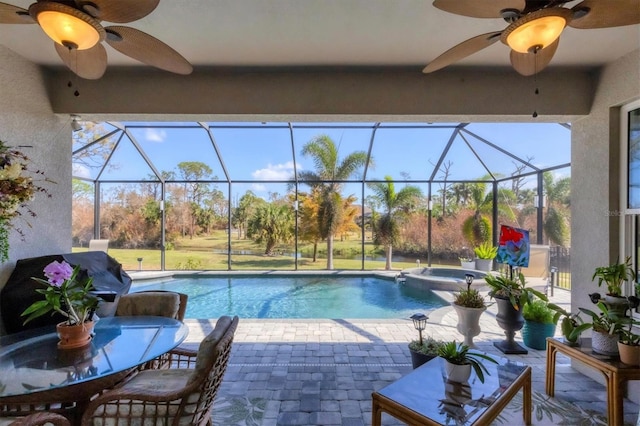 view of pool with an in ground hot tub, ceiling fan, a patio, and a lanai