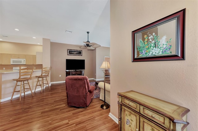 living room featuring light hardwood / wood-style floors and ceiling fan