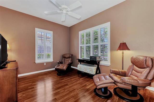 living area featuring dark wood-type flooring and ceiling fan