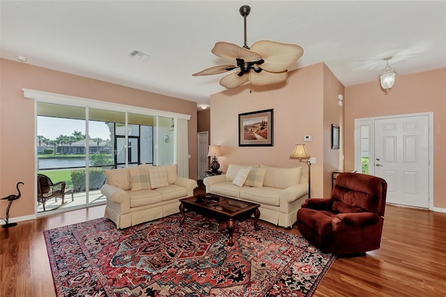 living room featuring a water view, hardwood / wood-style flooring, and ceiling fan