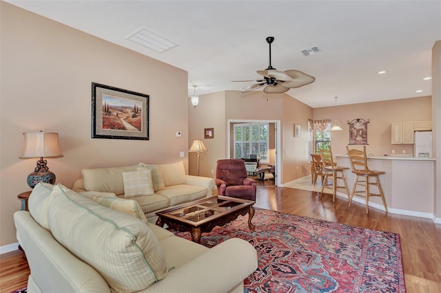 living room with ceiling fan and light hardwood / wood-style flooring