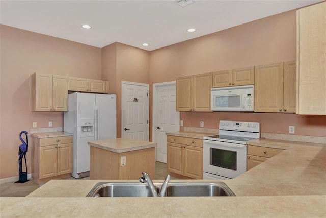 kitchen featuring a center island, a towering ceiling, light tile patterned floors, sink, and white appliances