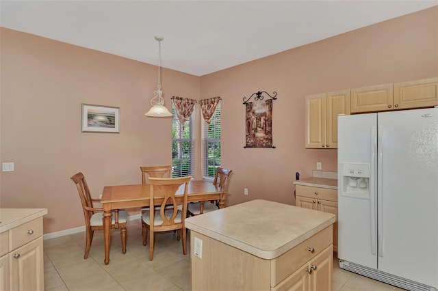 kitchen with decorative light fixtures, light tile patterned floors, white refrigerator with ice dispenser, and a center island