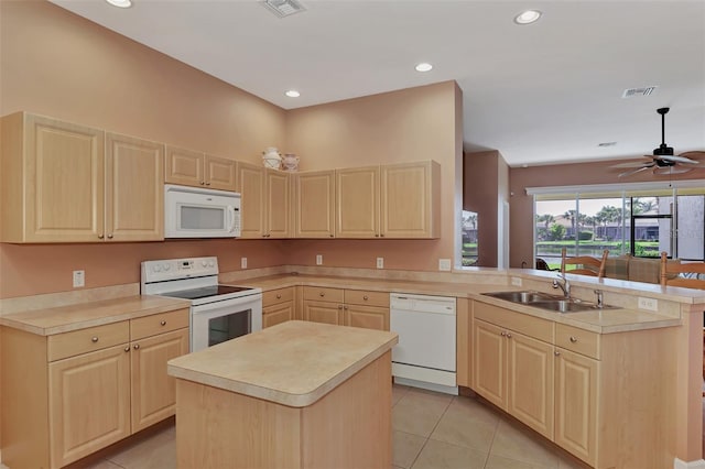 kitchen with sink, kitchen peninsula, light tile patterned floors, white appliances, and a kitchen island