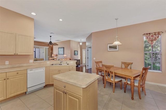 kitchen featuring sink, light tile patterned floors, hanging light fixtures, a center island, and dishwasher