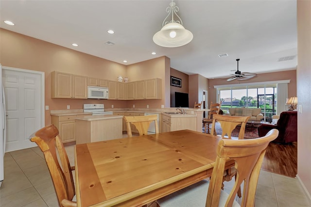 dining space featuring light tile patterned floors, sink, and ceiling fan