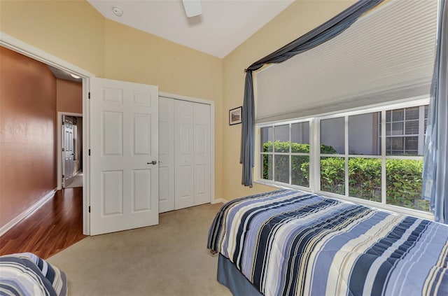 carpeted bedroom with ceiling fan and a closet