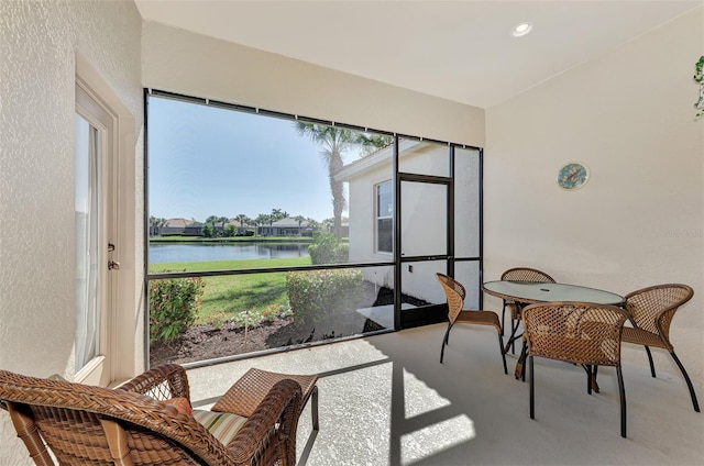 sunroom / solarium featuring plenty of natural light and a water view