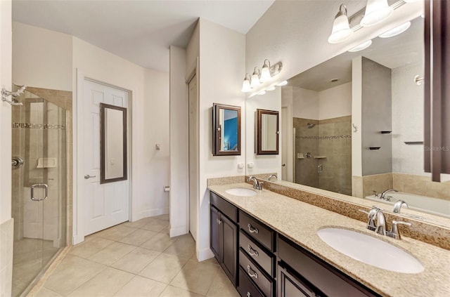 bathroom featuring tile patterned floors, a stall shower, double vanity, and a sink