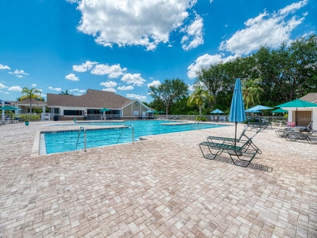 community pool featuring fence and a patio area