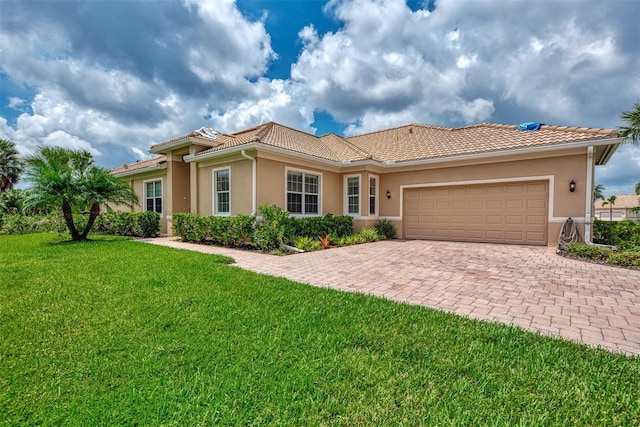 mediterranean / spanish home featuring a garage and a front lawn