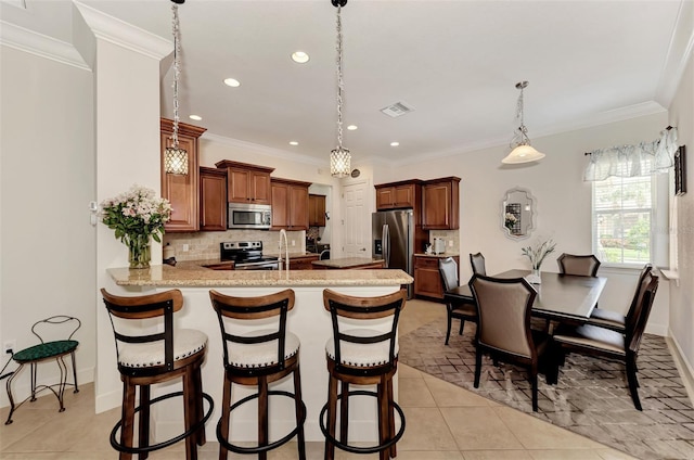 kitchen featuring appliances with stainless steel finishes, light tile patterned floors, decorative backsplash, and kitchen peninsula