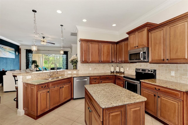 kitchen featuring a kitchen island, appliances with stainless steel finishes, sink, hanging light fixtures, and kitchen peninsula