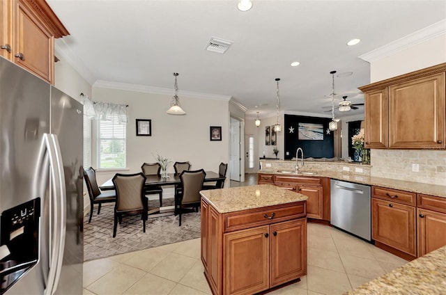 kitchen with stainless steel appliances, decorative light fixtures, sink, and light tile patterned floors