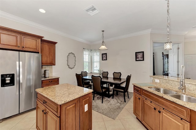 kitchen featuring sink, light tile patterned floors, stainless steel refrigerator with ice dispenser, a kitchen island, and decorative light fixtures