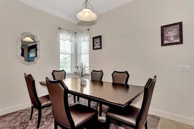 tiled dining room featuring crown molding