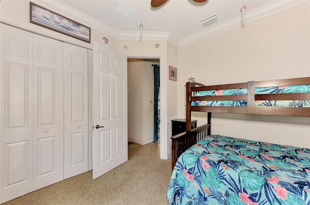 bedroom with light carpet, crown molding, a closet, and ceiling fan