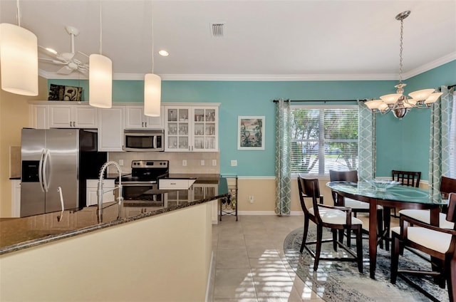 kitchen featuring white cabinetry, sink, pendant lighting, and appliances with stainless steel finishes