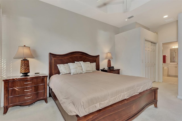 bedroom featuring ensuite bathroom, ceiling fan, and light carpet