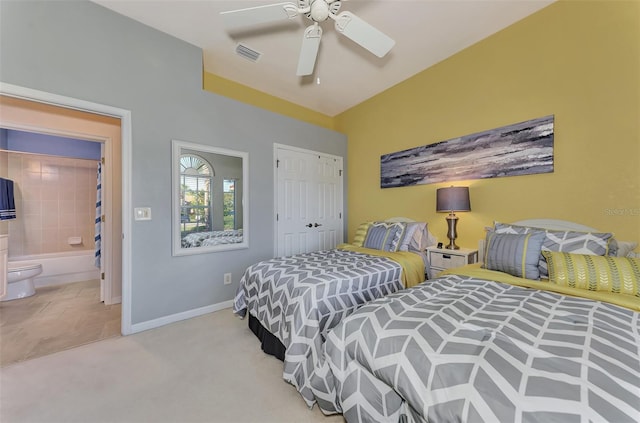 carpeted bedroom with a closet, ceiling fan, and ensuite bathroom