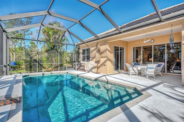 view of swimming pool with glass enclosure and a patio