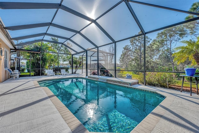 view of swimming pool featuring glass enclosure and a patio