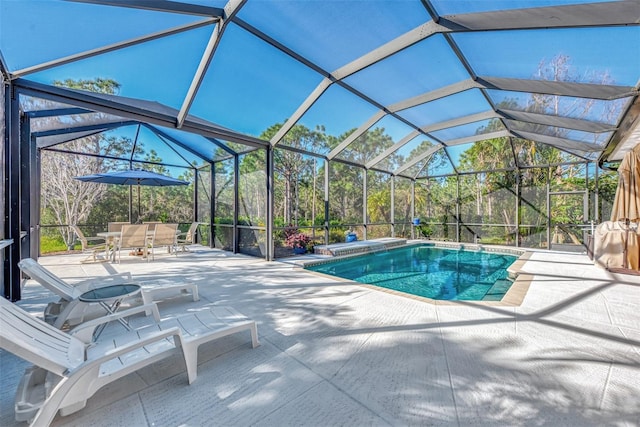 view of swimming pool featuring glass enclosure and a patio area