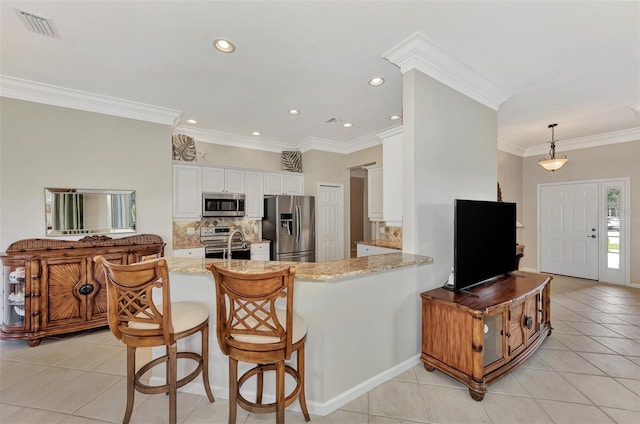 kitchen with kitchen peninsula, decorative backsplash, white cabinetry, appliances with stainless steel finishes, and decorative light fixtures