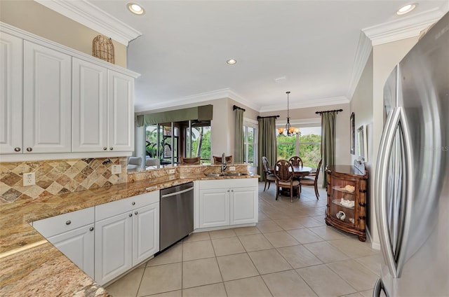 kitchen featuring white cabinetry, appliances with stainless steel finishes, hanging light fixtures, and sink