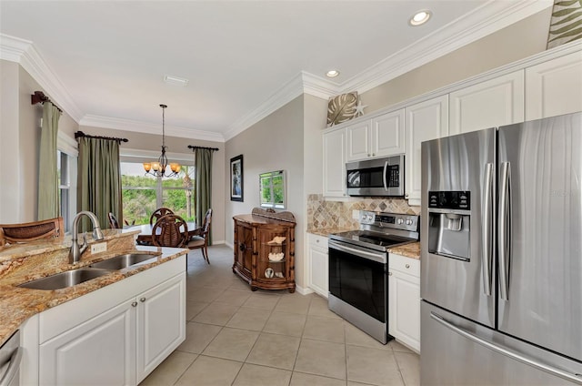 kitchen featuring stainless steel appliances, white cabinetry, sink, light stone countertops, and a chandelier