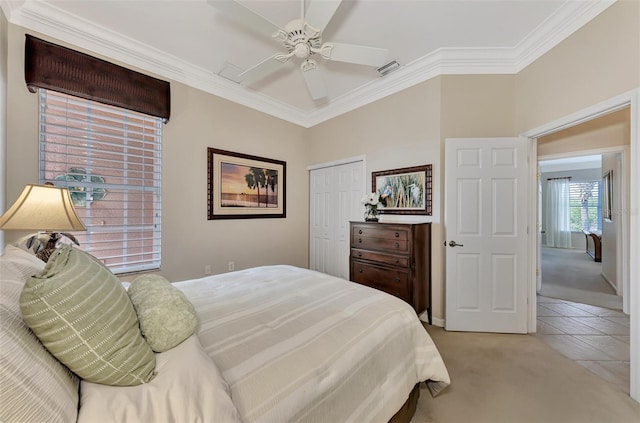 carpeted bedroom featuring ceiling fan, crown molding, and a closet