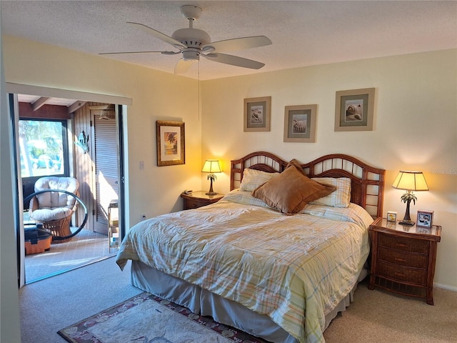 carpeted bedroom with a textured ceiling and ceiling fan