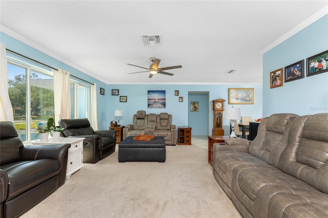 living room featuring a textured ceiling, ornamental molding, light colored carpet, and ceiling fan