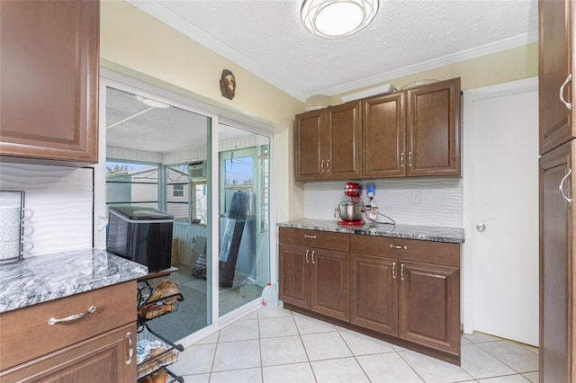 kitchen featuring crown molding, light stone countertops, and a textured ceiling