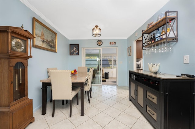 dining room with ornamental molding and light tile patterned floors