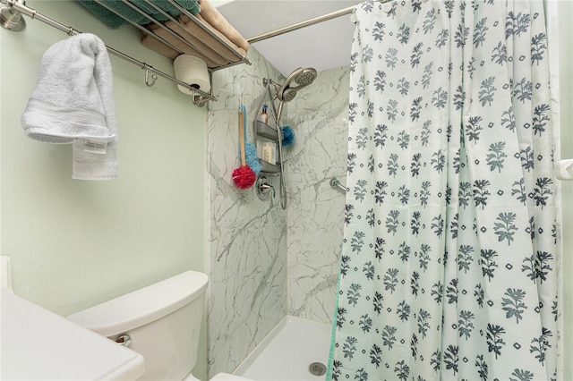 bathroom featuring toilet and curtained shower