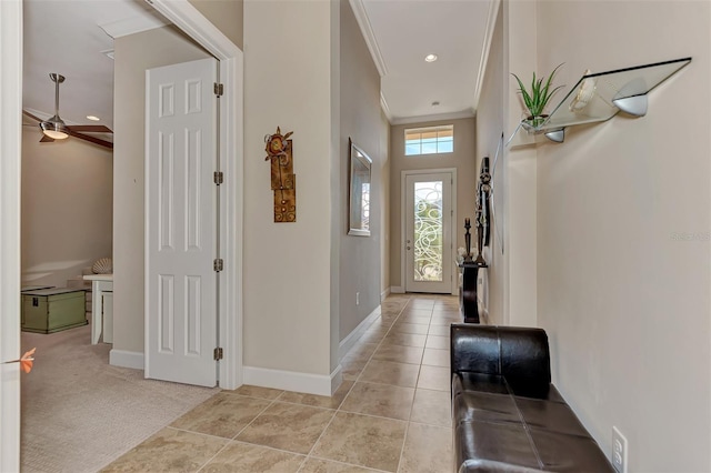 doorway featuring crown molding, light carpet, and ceiling fan