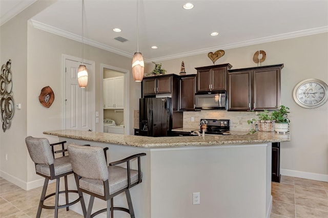 kitchen featuring tasteful backsplash, dark brown cabinets, washer and dryer, refrigerator with ice dispenser, and pendant lighting