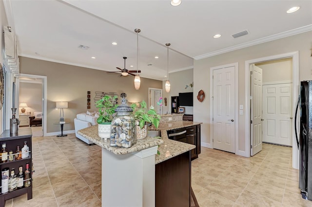 kitchen featuring hanging light fixtures, a center island with sink, ornamental molding, light stone countertops, and ceiling fan