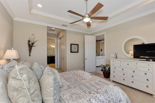 carpeted bedroom featuring a raised ceiling, ceiling fan, crown molding, ensuite bathroom, and a closet