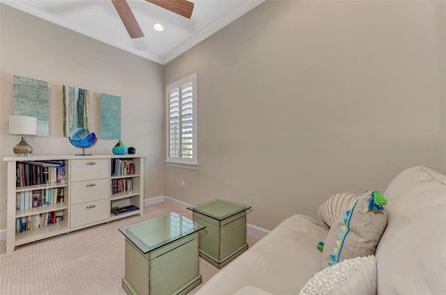 sitting room with light carpet, ornamental molding, and ceiling fan