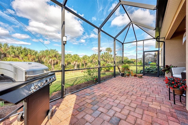 view of patio featuring grilling area and glass enclosure